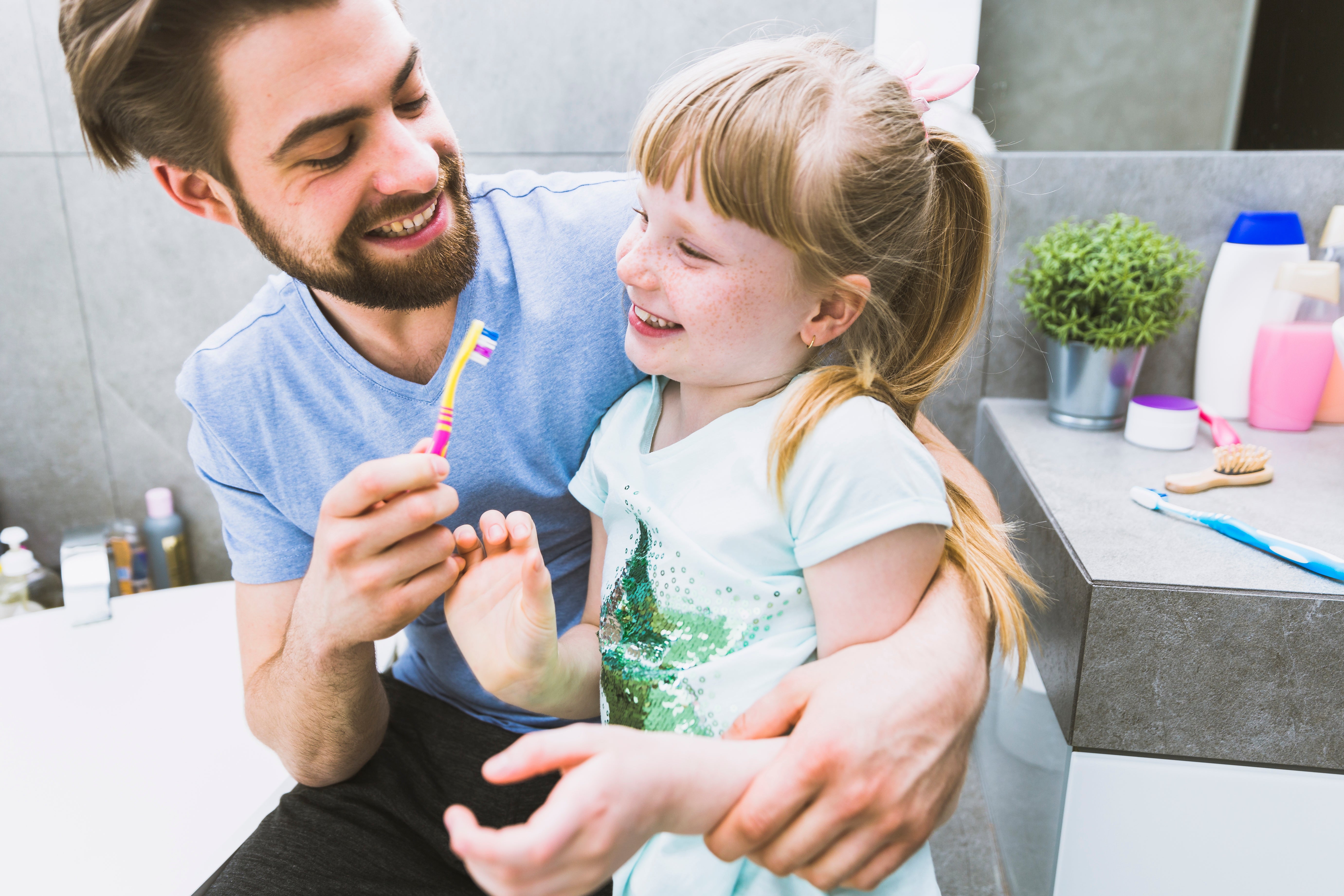 cheerful-father-daughter-brushing-teeth.jpg